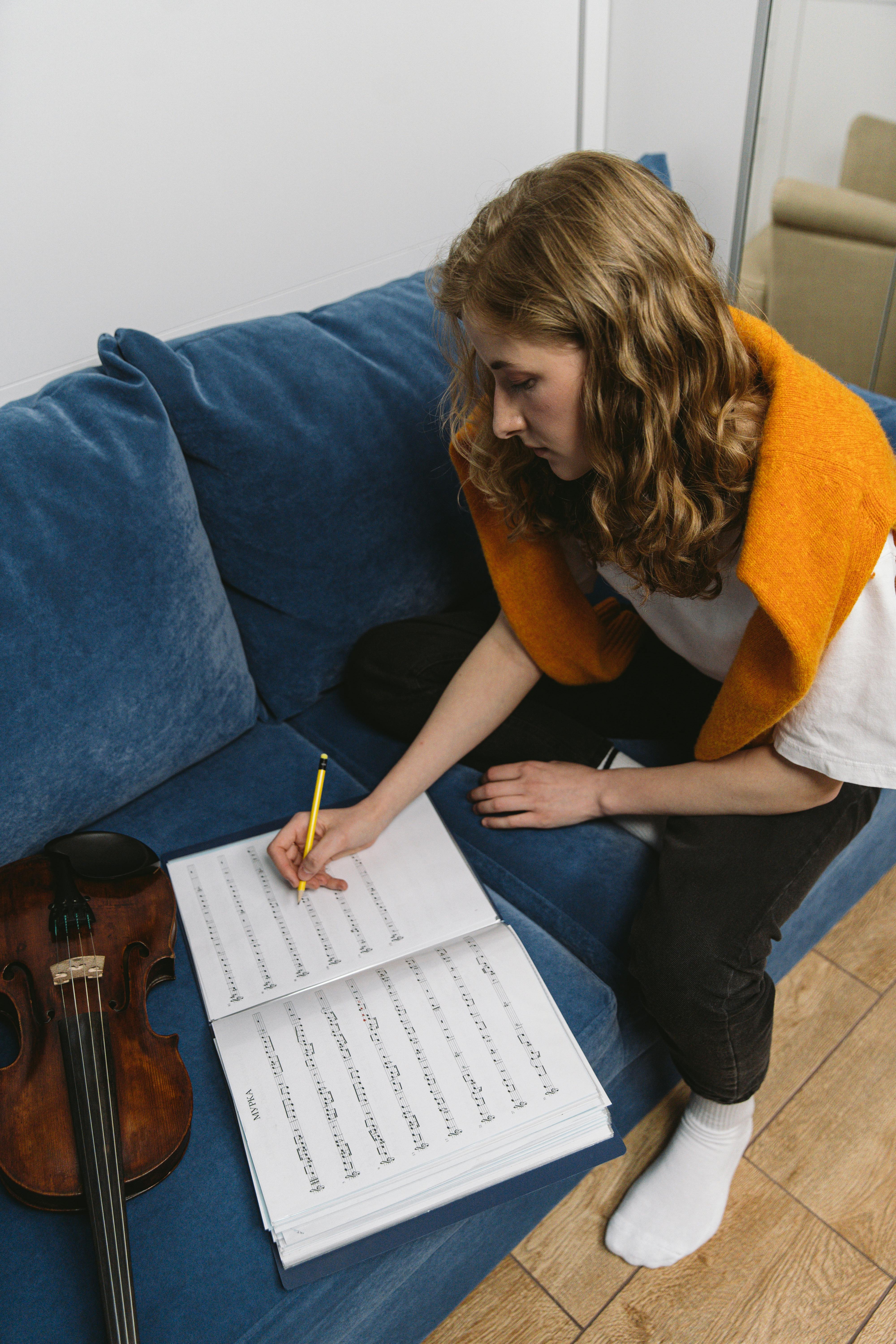 Student at the piano, smiling with a music book